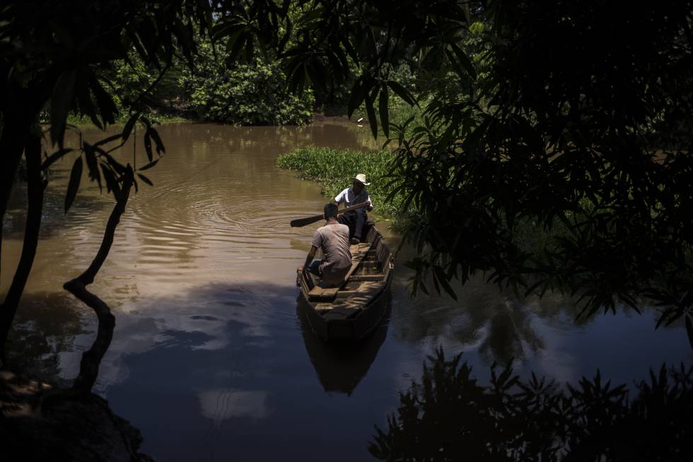 Dos hombres navegan por el río Pacayá